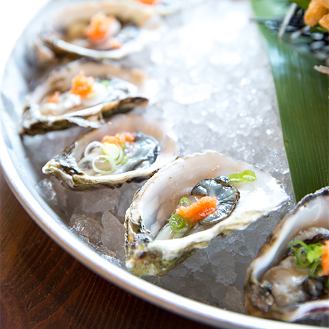 platter of oysters surrounding dipping sauce